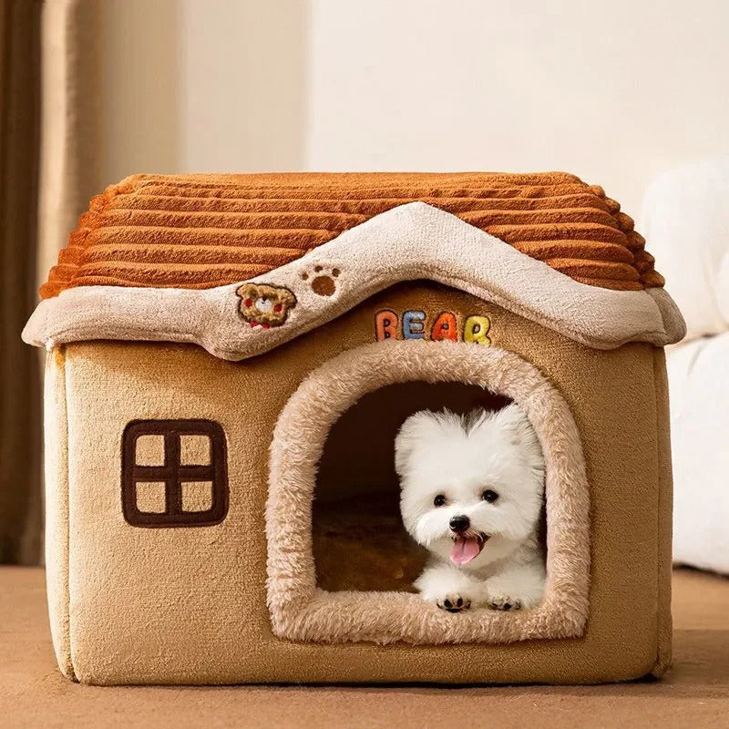 Petit chien blanc allongé dans une niche pour chien marron au design chalet, avec toit amovible et entrée en tissu peluche. Disponible chez Museau Dort.