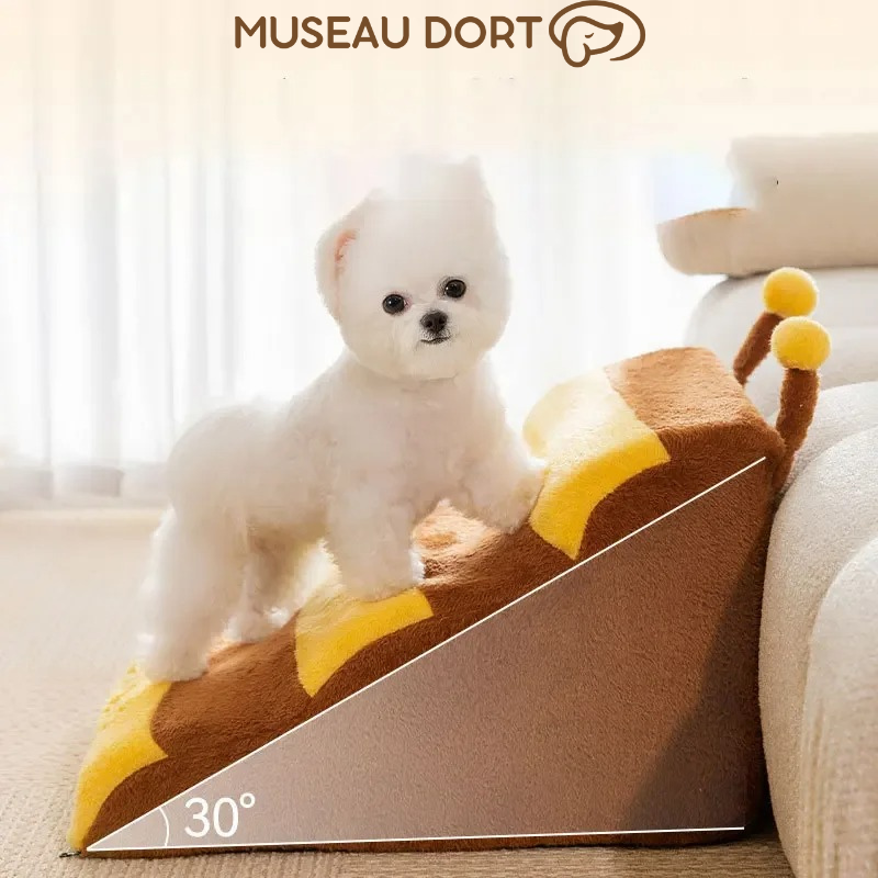 Petit chien blanc sur escalier antidérapant motif abeille à 30° pour accéder au canapé. Disponible chez Museau Dort
