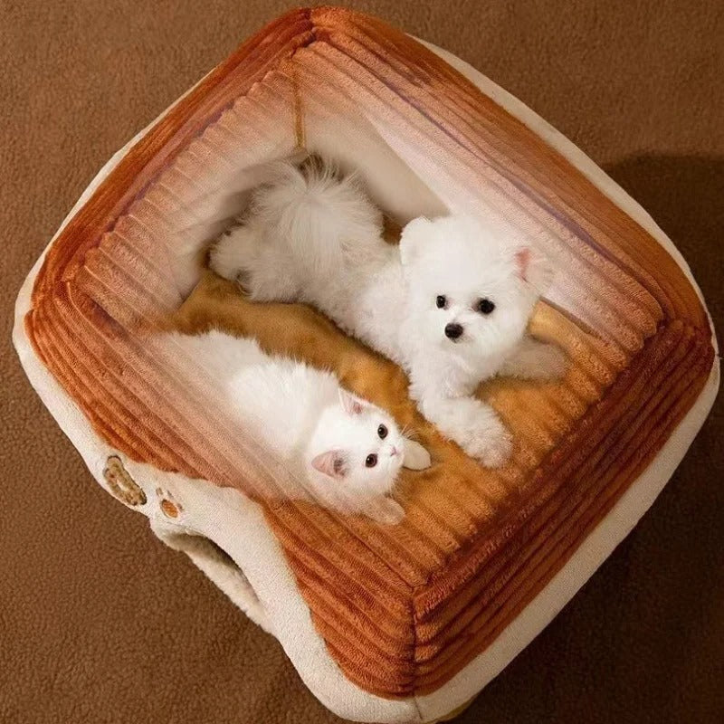 Petit chien blanc et chat blanc allongés côte à côte sur le toit amovible d’une niche pour chien en tissu doux marron, vue du dessus. Disponible chez Museau Dort.

