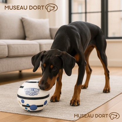 Dobermann jouant avec la balle sonore Wobble Wag Giggle dans un salon moderne, jouet interactif anti-ennui.