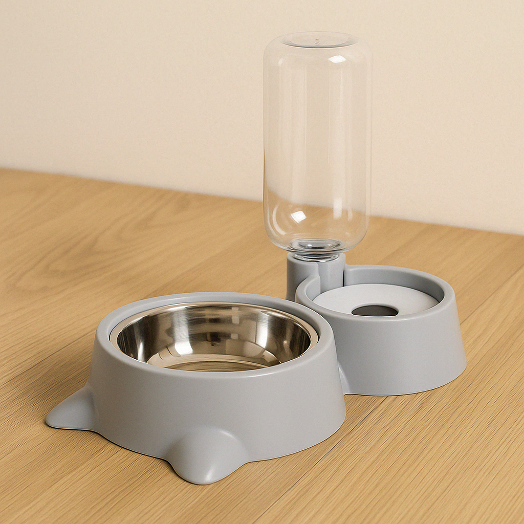 Gamelle grise pour chien ou chat avec bol en inox et distributeur d’eau automatique sur fond bois. Disponible chez Museau Dort.
