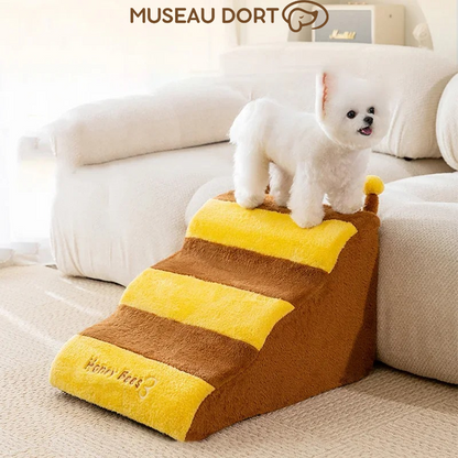 Petit chien blanc en haut d’un escalier antidérapant motif abeille, modèle 3 marches. Disponible chez Museau Dort
