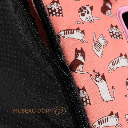 Détail de la fermeture éclair noire et du tissu rose à motifs chats de la maison pour chien pliable.