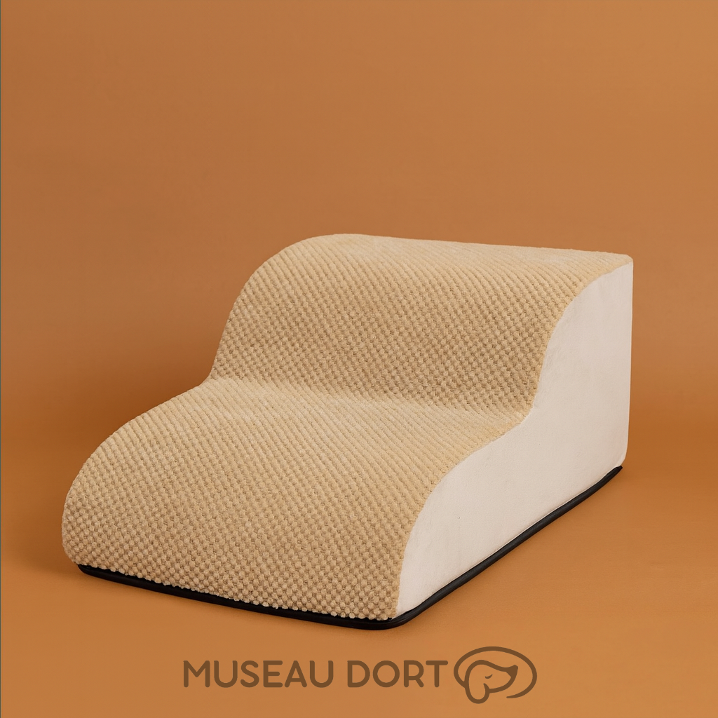 Escalier pour chien deux marches en tissu beige, présenté sur fond studio couleur terre cuite. Disponible chez Museau Dort
