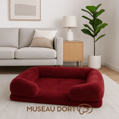 Lit pour chien confortable et orthopédique bordeaux dans un salon moderne, couchage moelleux et stable pour le repos.