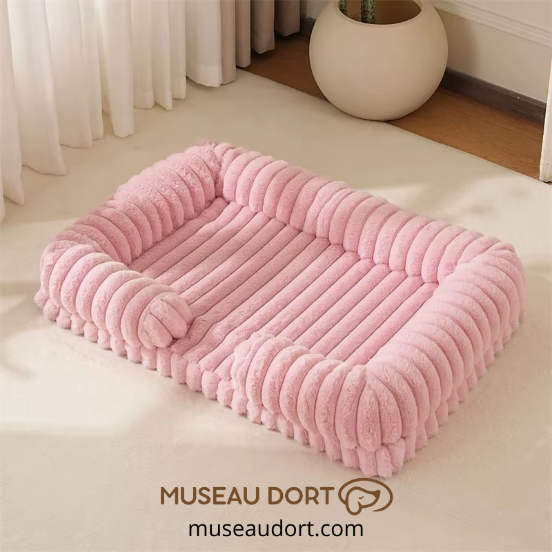Lit pour chien orthopédique rose avec rebords rassurants dans un salon, disponible chez Museau Dort