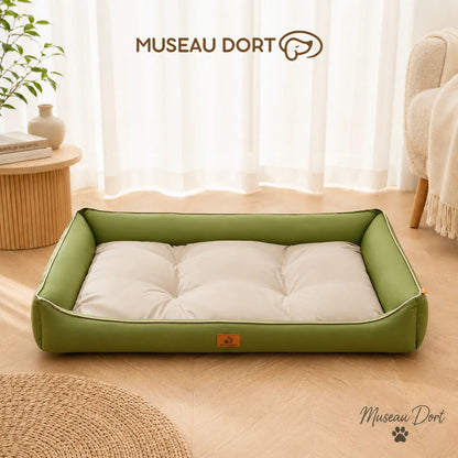 Panier chien imperméable vert avec coussin clair dans un salon lumineux, visuel officiel Museau Dort