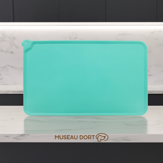 Tapis antidérapant vert pour gamelle de chien posé sur un plan de travail en marbre dans une cuisine moderne. Disponible chez Museau Dort.